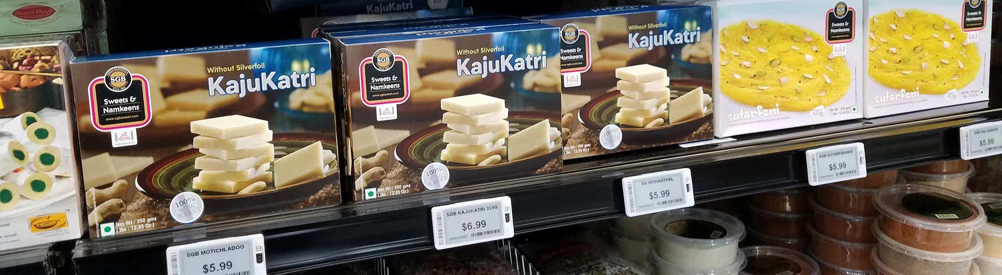 Boxes of Kaju Katli sweets on a supermarket shelf