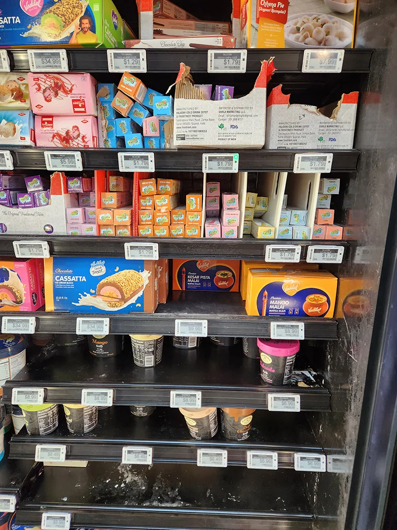 Supermarket freezer display with assorted ice cream, kulfi, and frozen dessert products