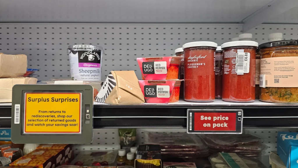 Discount grocery shelf with surplus food items, sauces, and labeled reduced-price products in supermarket