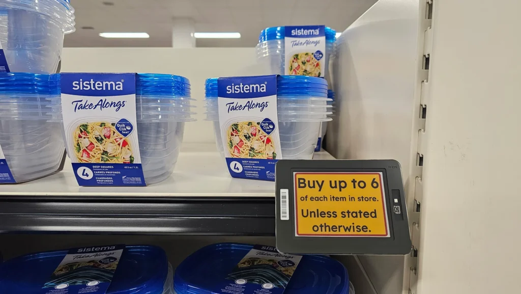 Plastic food storage containers displayed on retail shelf with purchase limit sign in store